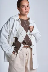 Sobrecamisa color beige de gabardina con cuello camisero, cierre frontal con botones a presión, dos bolsillos de parche en el pecho y corte holgado.