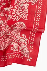 Pañuelo cuadrado rojo con estampado paisley en blanco y borde con diseño geométrico.