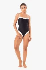 Traje de baño enterizo color marrón con contorno blanco y tirantes finos.