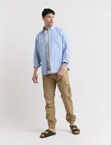 Pantalón cargo color verde con bolsillos laterales con fuelle y tobillos ajustados con elástico.