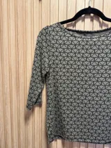 Buzo de tejido fino color gris con estampado geométrico en negro y mangas 3/4. Tiene spandex.