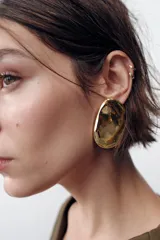 Aros metálicos dorados con forma irregular. Cierre con tuerca y clip.