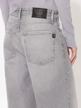 Pantalón de jean gris de corte ancho, tiro alto y largo hasta los tobillos.