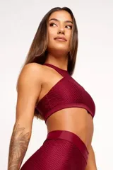 Top deportivo verde con textura tipo panal 3D, cuello alto y estructura firme.