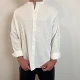 Camisa blanca de manga larga con cuello mao y corte regular.