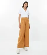 Pantalón pantalona color marrón, de lino y viscosa, con cintura elástica, bolsillos laterales y corte amplio.