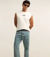 Pantalón de jean celeste con lavado dirty, corte flare, cintura fija con trabillas, cierre con botón y cremallera, y bolsillos.