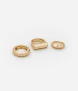 Set de tres anillos dorados con diferentes diseños geométricos.