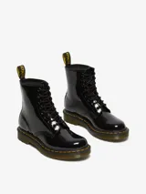Bota acordonada de charol negro con costuras amarillas en la suela y tirador trasero con el logo de la marca.