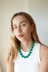 Collar de cuentas esféricas grandes de acrílico blanco, ensartadas en un cordón claro.