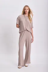 Pantalón largo de lanilla color taupe, de corte ancho y textura acanalada, con aberturas laterales en el ruedo.