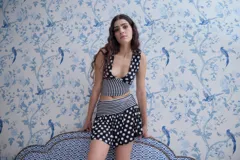 Top corto de lycra y algodón con estampado de lunares en blanco y negro en la parte superior y rayas verticales en blanco y negro en la parte inferior. Escote en V.