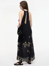 Vestido largo negro con breteles finos y bordado dorado.