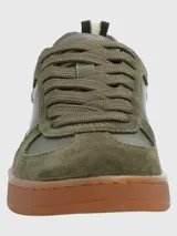 Zapatillas deportivas de cuero y descarne color verde oliva, con cordones y suela marrón de goma.