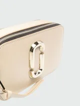 Cartera bandolera Marc Jacobs modelo The Snapshot DTM, color beige con correa ancha con el logo de la marca en relieve.