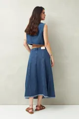 Falda midi de denim negro con tiro bajo, corte evasé, costuras verticales y ruedo desflecado.