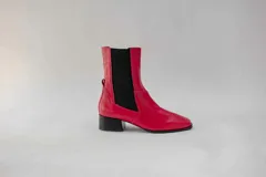 Botas de cuero rojas con elástico negro en los laterales, punta cuadrada y taco bajo.
