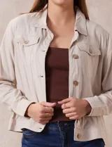 Campera de lino color beige, marca Dash, con abertura central y botones. Tiene bolsillos aplicados en la parte delantera.