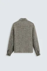 Sobrecamisa de hombre regular fit confeccionada en tejido con estructura irregular en tonos beige, marrón y negro. Tiene cuello solapa, manga larga con puños abotonados, bolsillos laterales y cierre frontal con cremallera.