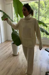 Conjunto de sweater y pantalón de punto color crema con diseño trenzado.