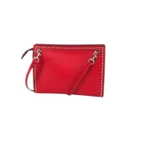 Bandolera roja de cuero con tachas plateadas en los bordes, bolsillo interior y correa extraíble.