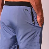 Short deportivo de hombre color celeste con cintura elástica negra, cordón de ajuste interno, bolsillos laterales y logo estampado en la pierna.
