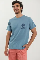 Remera celeste con estampado de palmeras y texto "St. Martin" en el pecho.