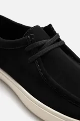 Zapato casual de cordones color negro, con capellada de cuero serraje, detalle de bordón en el empeine y suela de goma color crema.