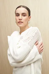 Sweater blanco de tejido de punto calado con escote redondo y mangas anchas.
