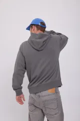 Hoodie gris de manga larga con capucha, corte holgado y bolsillo canguro.