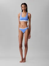 Conjunto Calvin Klein color celeste, compuesto por un corpiño deportivo con espalda racerback y una bombacha colaless. Ambos tienen cintura elástica blanca con el logo de la marca.