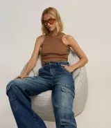 Pantalón wide leg de jeans con trabillas en la cintura, cierre por botón y cremallera, y bolsillos cargo.
