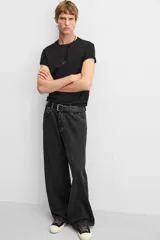 Pantalón de jean negro de corte amplio, con cinco bolsillos, efecto lavado y cierre frontal con cremallera y botón.