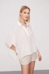 Blusa holgada color blanco con cuello tipo polo y mangas cortas, confeccionada en viscosa.