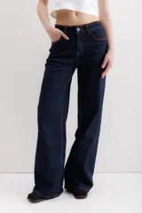 Pantalón de jean azul oscuro, de corte wide leg, con cintura alta y detalles de costuras en marrón.