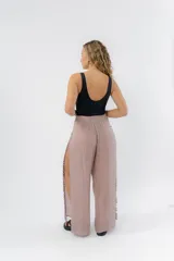 Pantalón blanco de gasa liviana con cintura elástica y aberturas laterales con detalle de pompones.