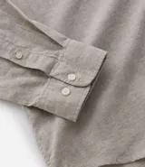 Camisa celeste de lino con cuello camisero, abotonadura frontal y mangas largas.