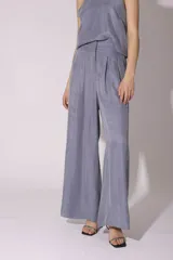 Conjunto de pantalón y top de seda color gris, con cuello halter y corte holgado.
