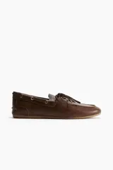 Zapatos náuticos de cuero marrón con cordones y costura de mocasín adelante. Forro en lona de algodón.