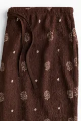Pantalón marrón de corte recto con estampado cachemir en color beige, cintura elástica con cordón ajustable.