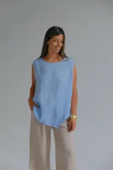 Musculosa celeste de lino italiano, de corte recto, con caída fluida, escote redondo y ruedo asimétrico.