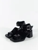 Sandalia negra de cuero con tira con hebilla y taco de 7,5 cm de altura.