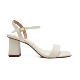 Sandalias de vestir color crema con punta cuadrada, tira delantera ancha y tira fina con hebilla al tobillo. Tacón cuadrado.