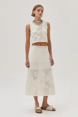 Top tejido de punto calado color crudo con diseño de flores, escote redondo y lurex en el escote.