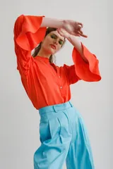 Blusa color naranja con escote mao y abertura frontal con botones. Mangas tres cuartos con detalles fruncidos.