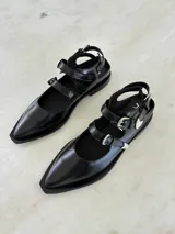 Ballerinas de cuero color marrón con punta fina y dos tiras con hebillas.