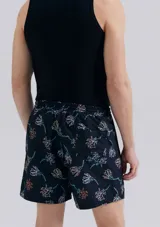 Short de baño blanco con estampado de hojas negras.