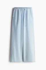 Pantalón de denim celeste de corte holgado con cintura elástica y cordón ajustable.