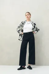 Pantalón de jean azul oscuro, de corte ancho y tiro alto, con bolsillos delanteros cuadrados y amplios.