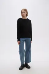 Sweater marrón de punto con textura trenzada, cuello redondo y mangas largas.